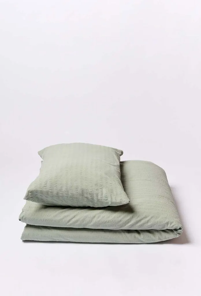 Ein ordentlich gefaltetes Bettwäsche Journey Living Kemeri Set in Hellgrün, mit Bett- und Kissenbezug, wird auf einem schlichten weißen Hintergrund präsentiert.