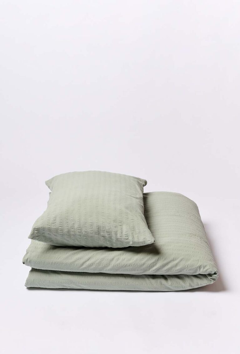 Ein ordentlich gefaltetes Bettwäsche Journey Living Kemeri Set in Hellgrün, mit Bett- und Kissenbezug, wird auf einem schlichten weißen Hintergrund präsentiert.