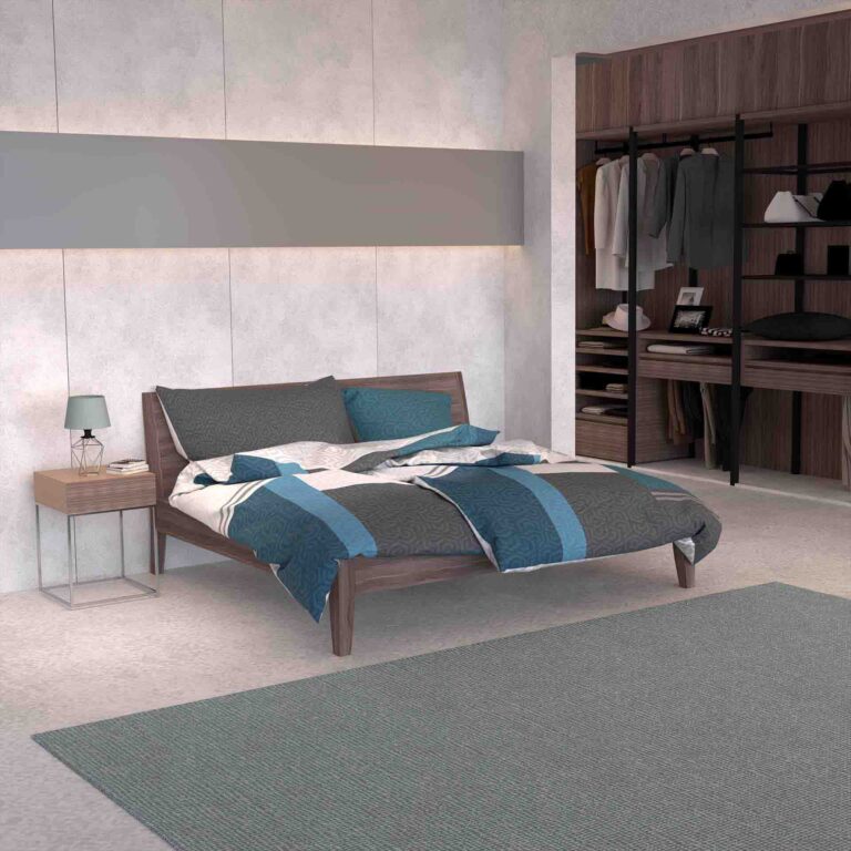 Ein modernes Schlafzimmer mit einem Holzbett mit Bettwäsche Joakim Lotus Création in Blau und Grau, einem Nachttisch mit einer Lampe, einem großen Teppich und einem offenen begehbaren Kleiderschrank mit Hänge- und Ablageflächen.