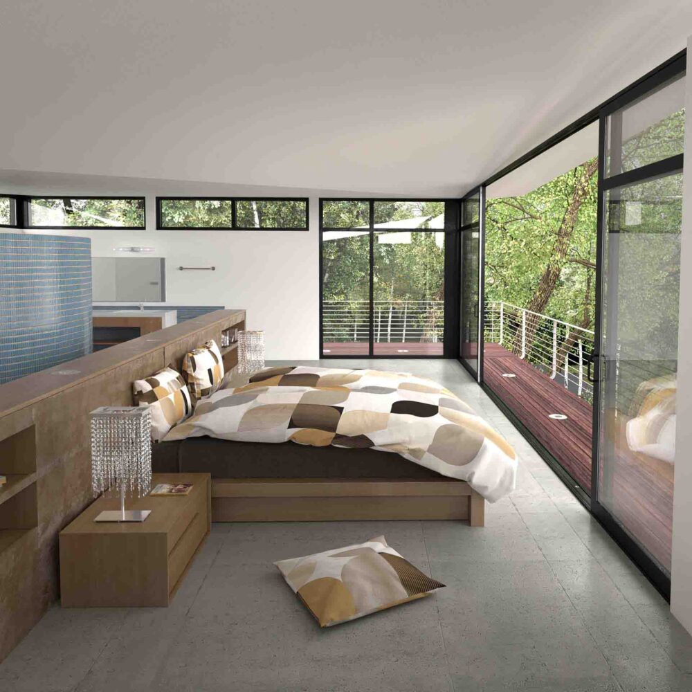 Ein modernes Schlafzimmer mit großen Fenstern und Glastüren gibt den Blick auf die Bäume draußen frei. Das Bett ist mit Bettwäsche Ophelia Lotus Création bezogen, flankiert von zwei Nachttischen mit Kristalllampen, während natürliches Licht den Raum erfüllt.