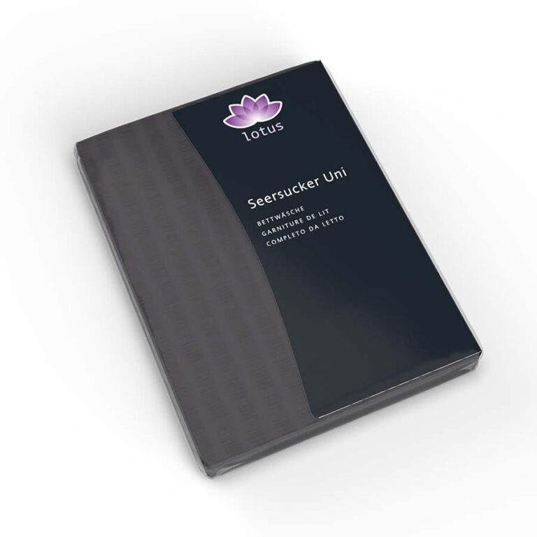 Ein verpacktes Set von Lotus Bettwäsche Satin Seersucker graphit, mit mehrsprachigem Text und einem lila Lotus-Logo auf einem modernen schwarzen und dunkelgrauen Design.