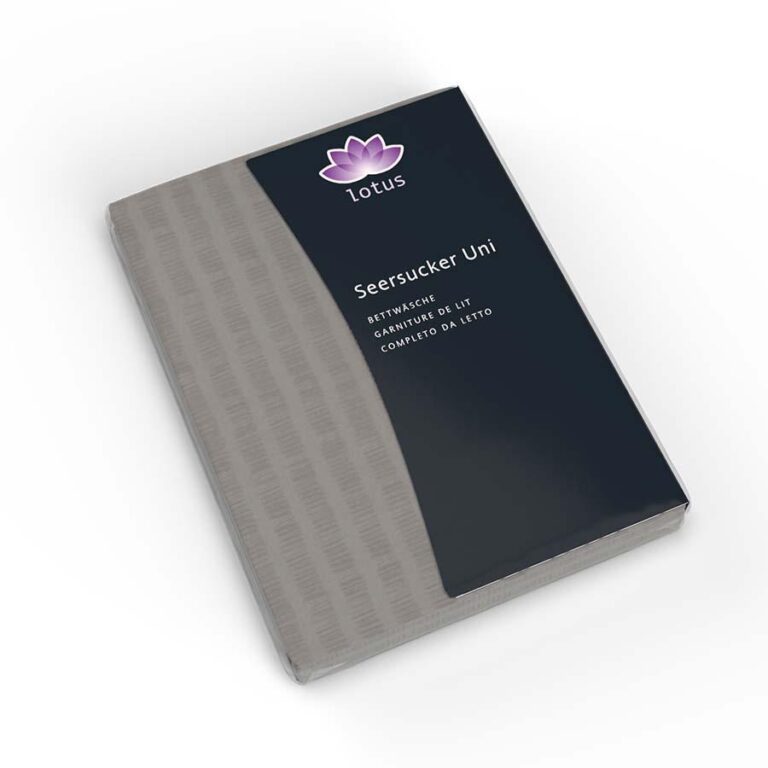 Ein verpacktes Bettwäsche Satin Seersucker titan Bettlaken mit der Aufschrift Lotus Seersucker Uni mit grauem Muster, in einer schwarz-grauen Schachtel mit lila Lotus-Logo und mehrsprachigem Text.