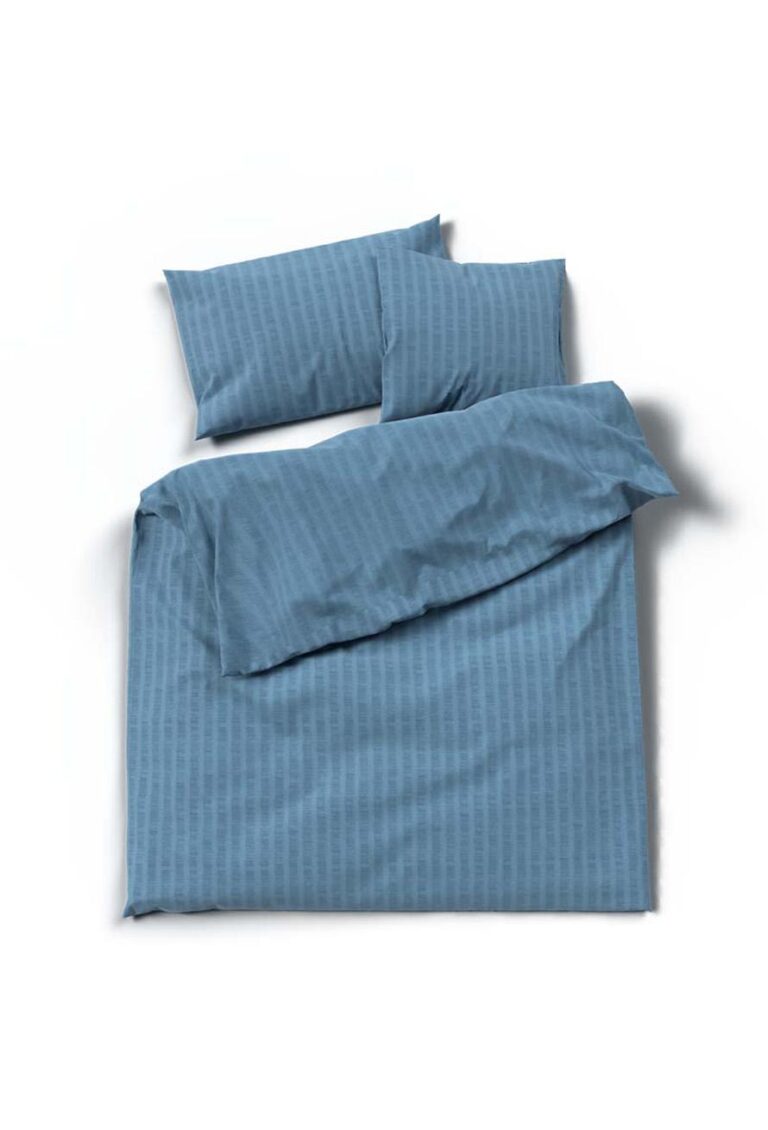 Ein ordentlich gemachtes Bett mit blauem Bettwäsche Satin Seersucker, mit dezenten Streifen auf dem Bettbezug und zwei passenden Kissen, vor einem schlichten weißen Hintergrund.