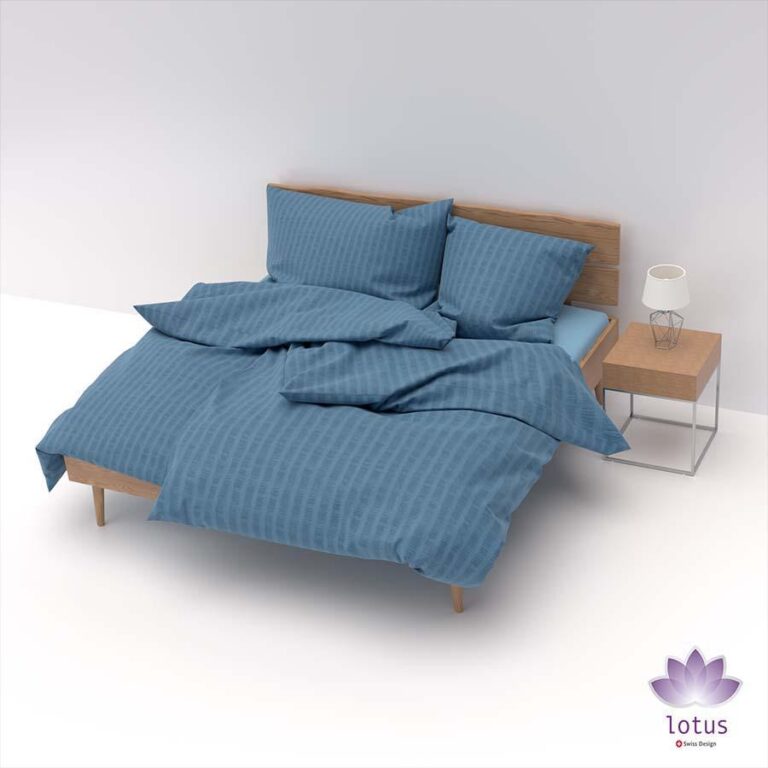 Ein modernes Holzbett mit Bettwäsche Satin Seersucker blau und zwei Kissen steht neben einem hölzernen Nachttisch mit einer Lampe, in einem minimalistischen weißen Raum. Das Logo der Marke Lotus ist in der unteren rechten Ecke zu sehen.
