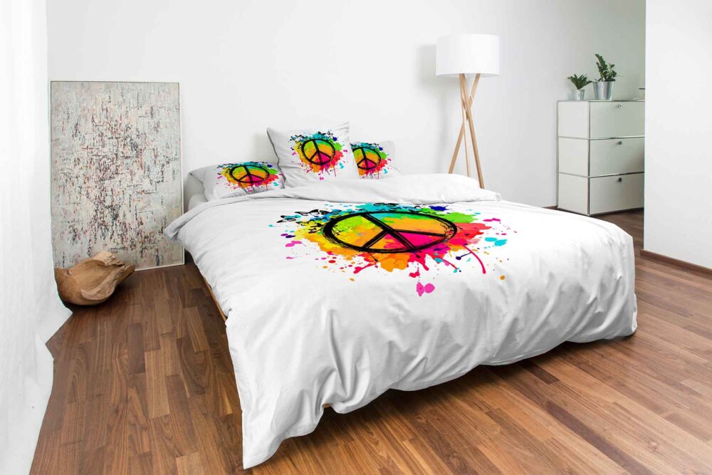 Modernes Schlafzimmer mit Holzboden, weißer Bettwäsche Night Fashion Peace und Kissen mit bunten Friedenszeichen, einer Stehlampe, abstrakten Kunstwerken und einer weißen Kommode mit Pflanzen.