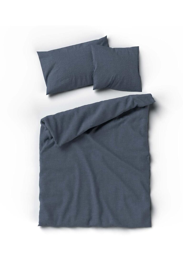 Ein ordentlich gemachtes Bett mit dem Bettbezug Bettwäsche Uni denim Hanf und zwei passenden Kissen, alle in Dunkelgrau, vor einem schlichten weißen Hintergrund, wobei die Oberseite der Bettdecke leicht zurückgeschlagen ist.