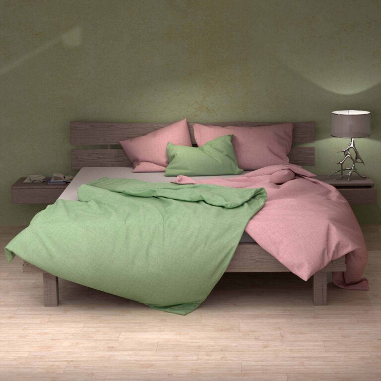 Ein modernes Holzbett mit Bettwäsche Uni Aloe Leinen in Rosa und Grün ruht vor einer grünen Wand. In der Nähe steht ein Nachttisch mit einer Lampe und Büchern, während das leicht zerknitterte Bettzeug den hellen Holzboden ergänzt.