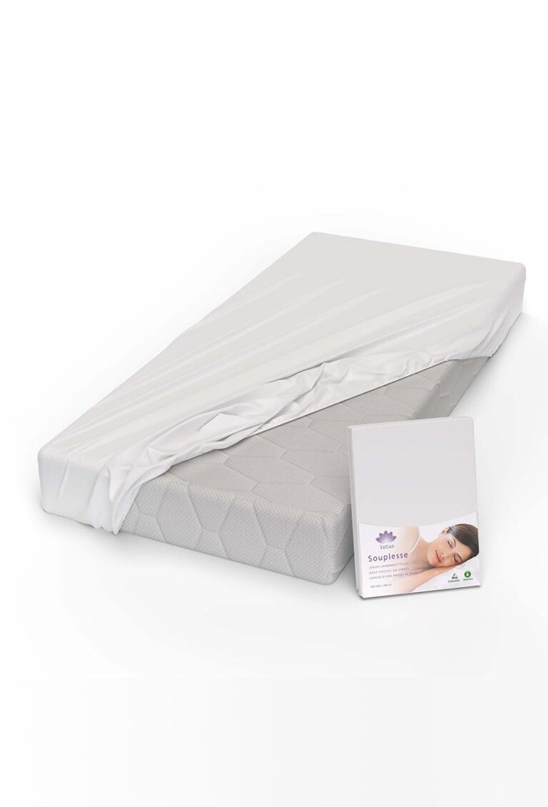 Eine Matratze mit einem weißen Lotus Fixleintuch Souplesse Jersey Spannbetttuch, das teilweise zurückgezogen ist, zeigt die strukturierte Oberfläche darunter. Auf einer Produktverpackung davor ist das Foto einer schlafenden Frau abgebildet.