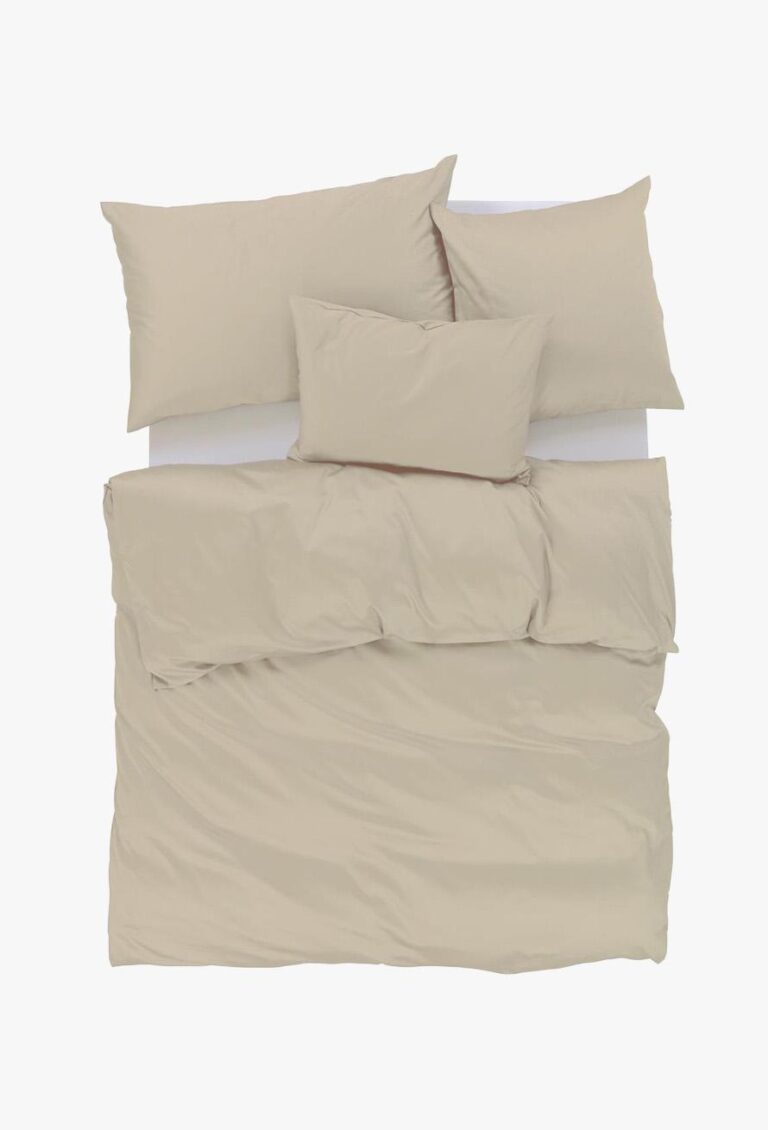 Draufsicht auf ein ordentlich gemachtes Bett mit beiger Bettwäsche, einschließlich zweier Kissen, eines langen rechteckigen Kissens und einer Bettdecke, alles vor einem weißen Hintergrund.