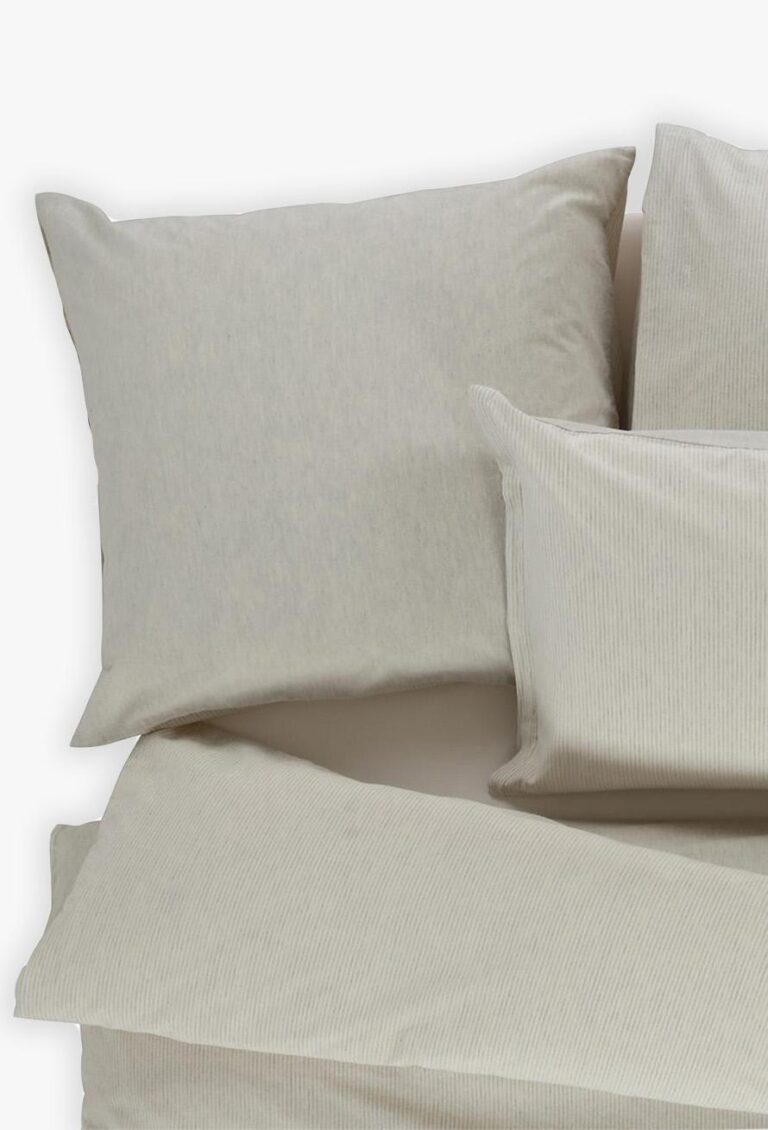 Ein ordentlich arrangiertes Set von Bettwäsche Tamara-R BeCosy Lee, mit hellbeigen gestreiften Kissenbezügen und einem passenden Bettbezug, auf einem Bett von oben gesehen vor einem schlichten Hintergrund.