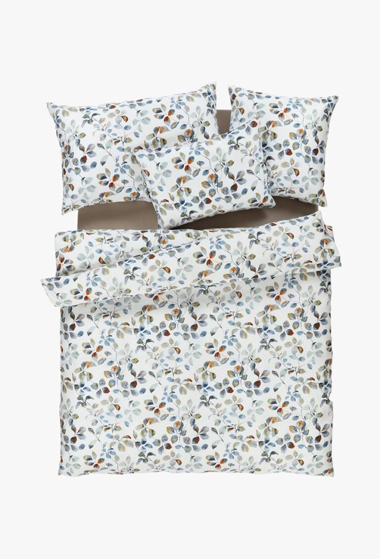 Die Bettwäsche Tamara-R BeCosy Maisy blau hat einen weißen Hintergrund mit einem farbenfrohen botanischen Druck von Blättern und Beeren in Blau, Orange, Braun und Grün. Das Set besteht aus einem Bettbezug und vier Kissenbezügen.