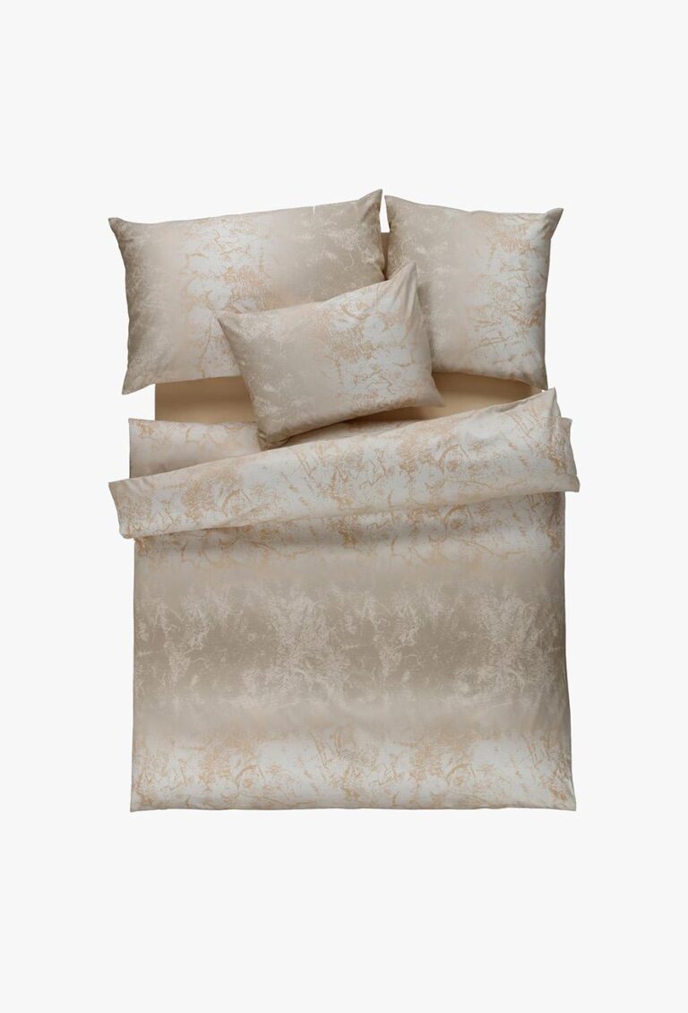 Die Bettwäsche Tamara-R Selection Royal creme besteht aus beige- und cremefarbener Bettwäsche, einer Bettdecke, zwei großen und zwei kleinen Kissen, die alle mit einem dezenten Marmormuster verziert sind.