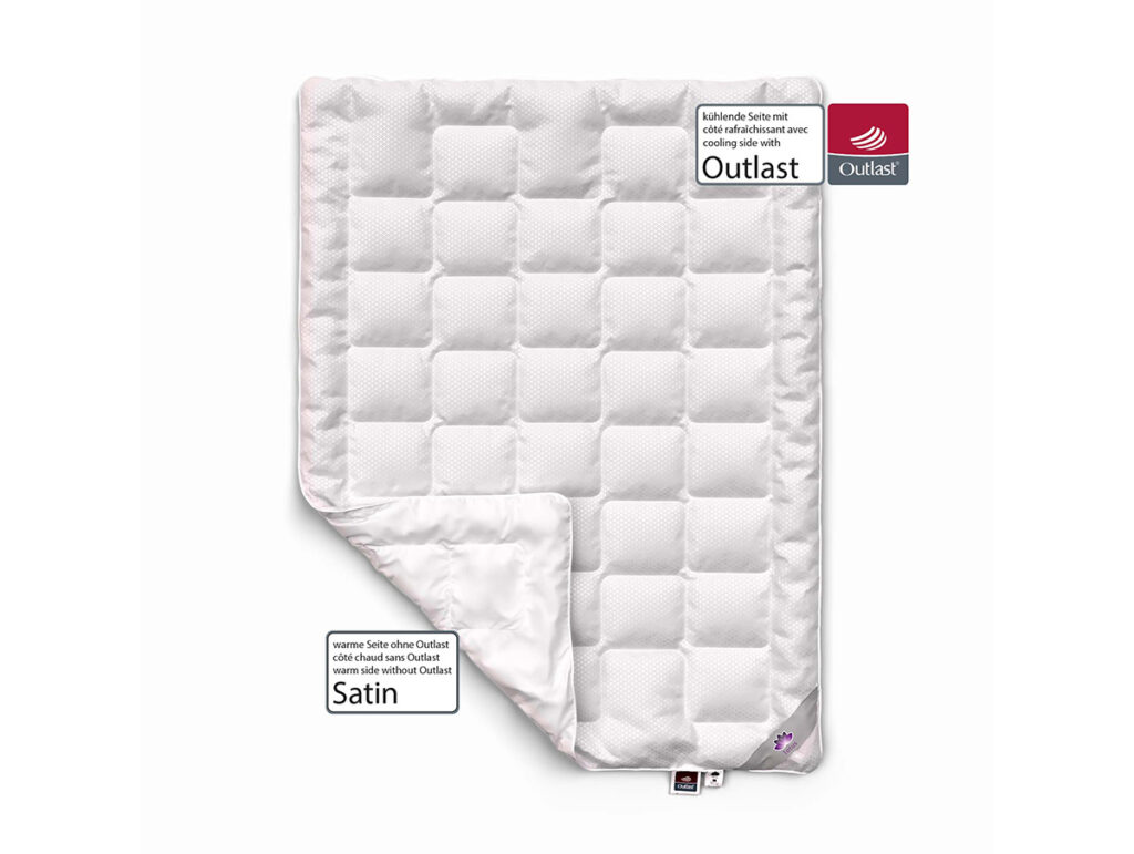 Eine weiße, gesteppte Satindecke mit einer umgeschlagenen Ecke, die mit Etiketten versehen ist, die die Kühltechnologie und das Satinmaterial hervorheben. Die Logos von Outlast und Satin sind in der oberen rechten und unteren linken Ecke zu sehen.