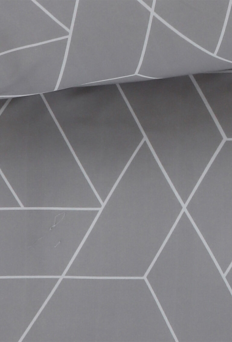 Die Bettwäsche TAMARA-R - A Colori Simon besteht aus grauem Stoff mit einem weißen geometrischen Muster aus sich kreuzenden Linien, die Rauten und Dreiecke bilden, und ist mit einer horizontalen Falte im oberen Bereich gefaltet.
