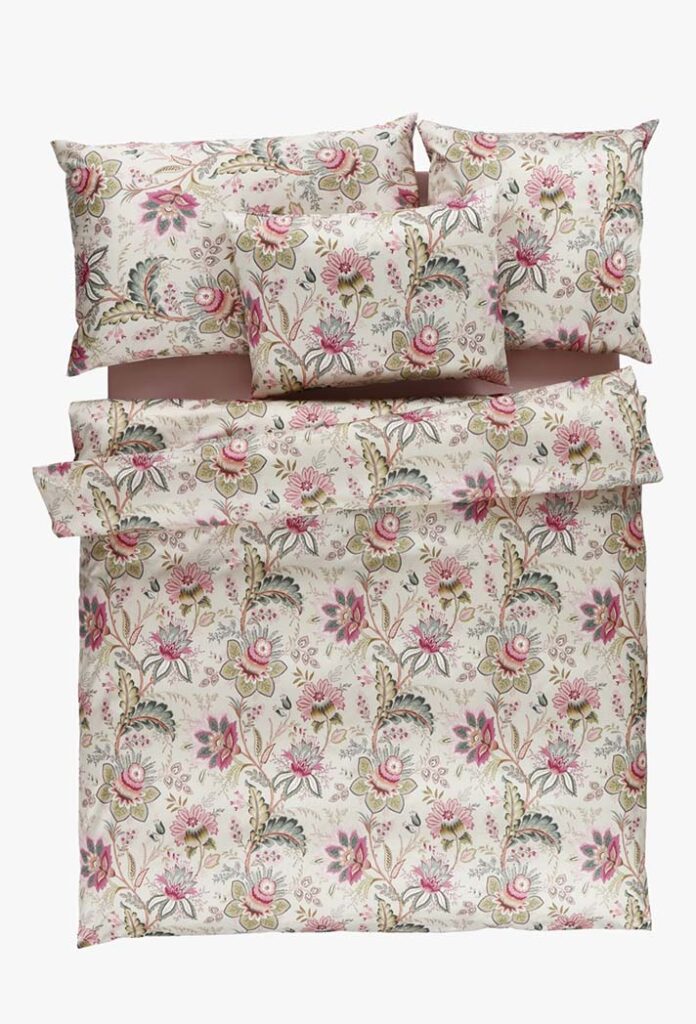 Das Bettwäsche-Set Tamara-R Selection Noelia besteht aus zwei Kissen und einem Bettbezug mit rosa, grünen und beigen Blumenmustern auf hellem Grund.