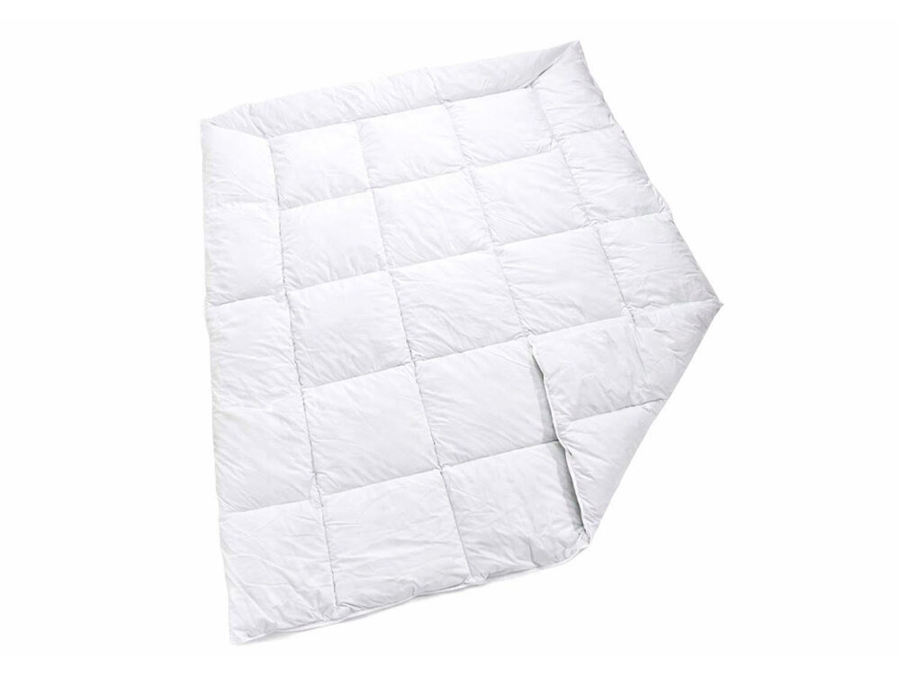 Eine weiße, gesteppte Bettdecke mit einem Gittermuster ist an einer Ecke leicht gefaltet und steht auf einem einfarbig weißen Hintergrund.