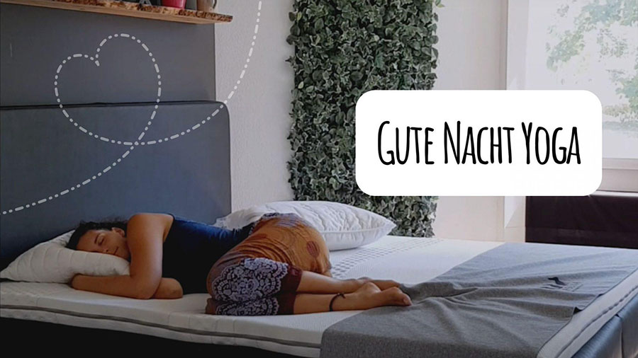 Eine Frau liegt auf der Seite im Bett und stützt ihren Kopf auf ein Kissen. Neben ihr steht eine buschige Grünpflanze an der Wand. Der Text lautet Gute Nacht Yoga. Über ihr ist eine Herzform gezeichnet. Sonnenlicht strömt durch ein Fenster herein.