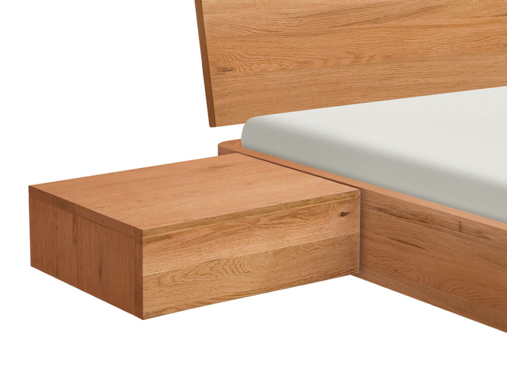 Eine Nahaufnahme eines hölzernen Bettrahmens mit einem dazugehörigen schwimmenden Nachttisch, beide aus hellem Holz. Das Bett hat eine weiße Matratze, und der Nachttisch hat ein einfaches, minimalistisches Design.