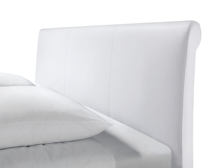 Eine Nahaufnahme des Hasena Bettes "Dream-Line Ciara 28 Fasio" mit einem weiß gepolsterten Kopfteil und zwei weißen Kissen, dargestellt vor einem schlichten weißen Hintergrund.