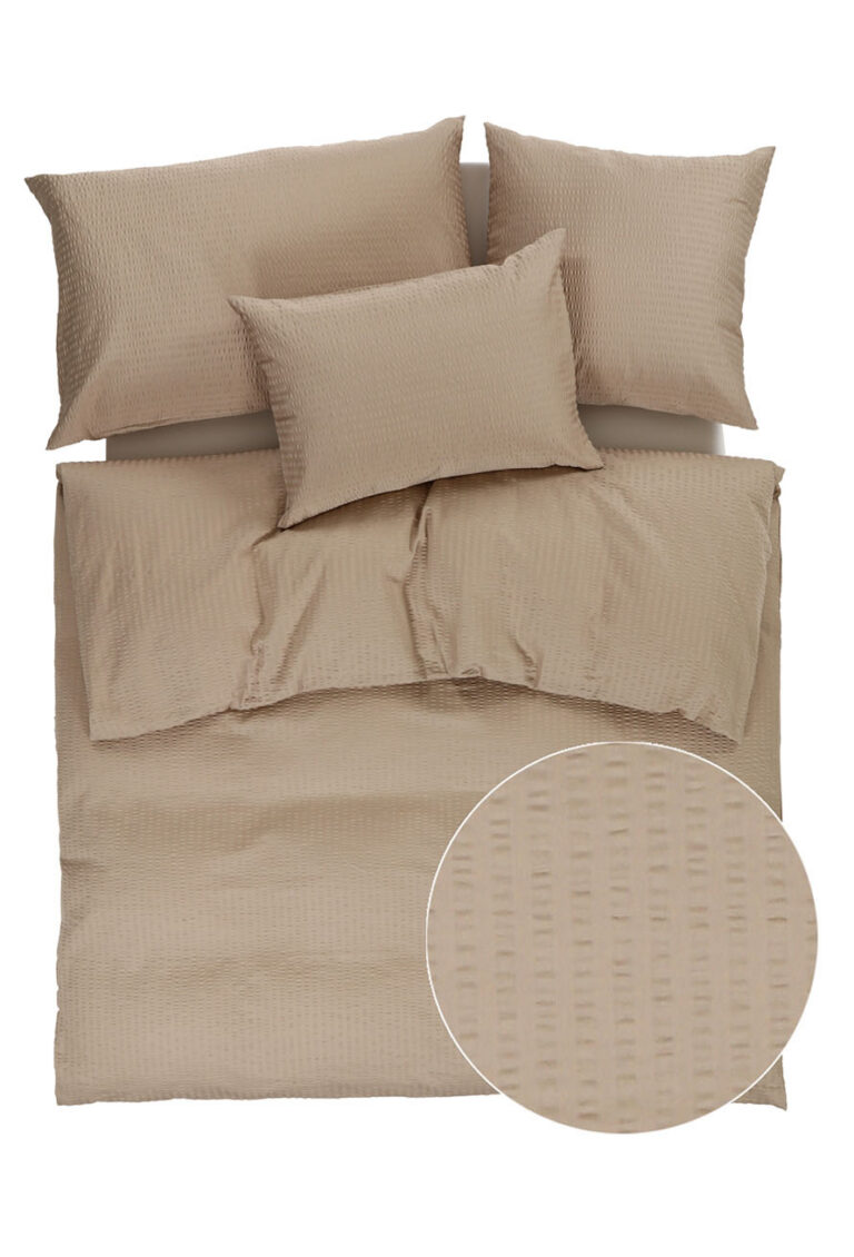 Beigefarbene Strukturbettwäsche mit einem Bettbezug und drei Kissen, von oben gezeigt. Ein eingearbeiteter Kreis hebt das Detail des subtilen vertikalen und horizontalen Webmusters des Stoffes hervor.