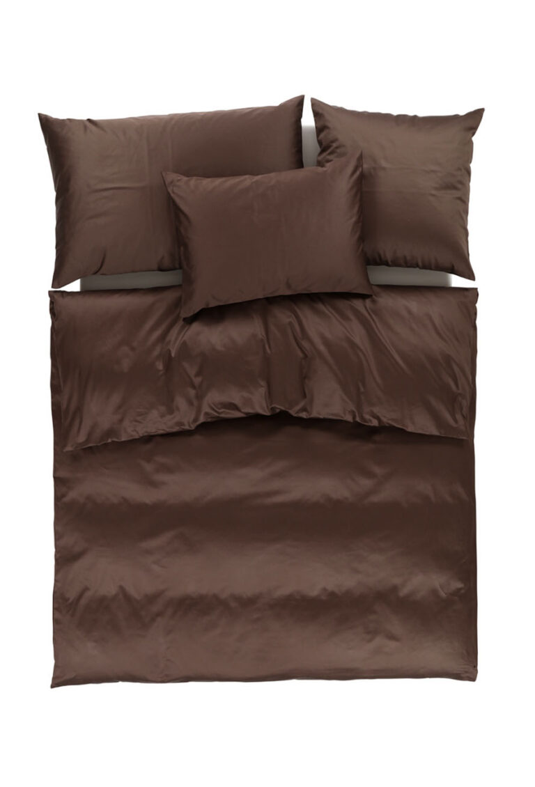 Ein ordentlich gemachtes Bett mit dunkelbrauner Bettwäsche, darunter ein Bettbezug, zwei große Kissen und ein kleineres Kissen, alles auf einem weißen Hintergrund.