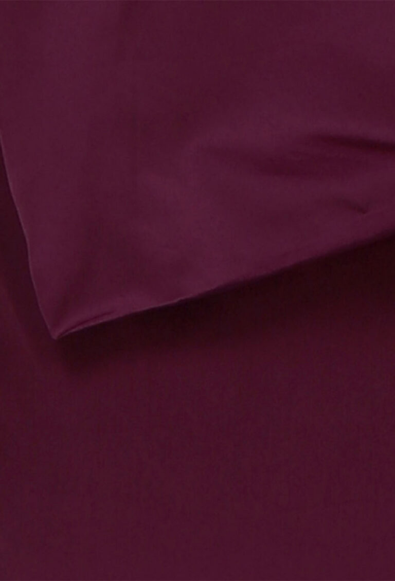 Nahaufnahme eines dunklen burgunder- oder kastanienbraunen Stoffes, der eine glatte Struktur und eine Eckfalte aufweist.