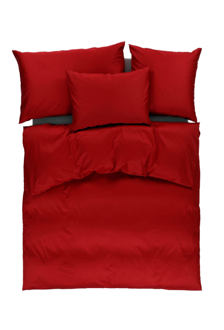 Ein ordentlich gemachtes Bett mit einem roten Bettbezug und vier passenden roten Kissen, von oben auf weißem Hintergrund fotografiert.