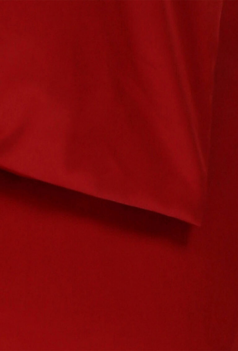 Nahaufnahme eines roten Stoffstücks mit weichen Falten und glatter Textur, das überlappende Ränder aufweist.