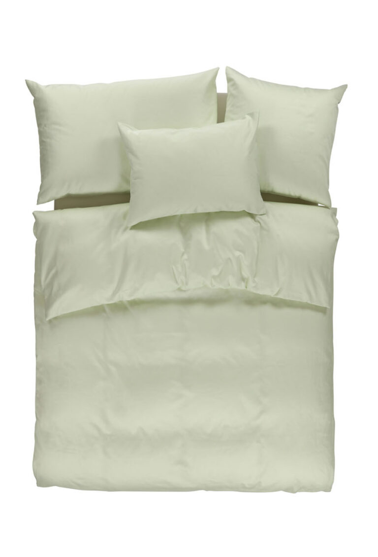 Draufsicht auf ein ordentlich gemachtes Bett mit hellgrüner Bettwäsche, einschließlich einer Bettdecke und vier Kissen, die in zwei Reihen vor einem weißen Hintergrund angeordnet sind.