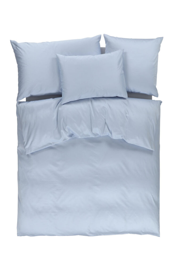 Ein ordentlich gemachtes Bett, von oben gesehen, mit hellblauem Bettzeug bedeckt, mit zwei Kissen oben, einem Kissen in der Mitte und einem Kissen unten, alles vor einem weißen Hintergrund.