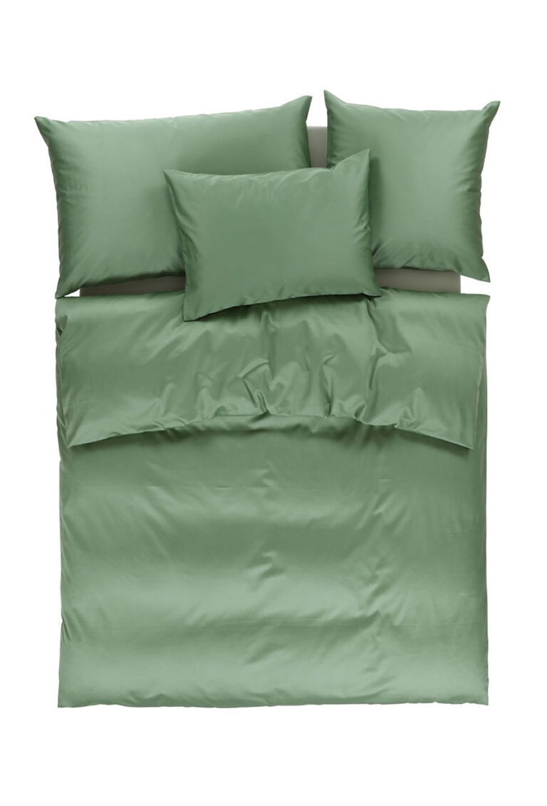 Ein ordentlich gemachtes Bett mit einer salbeigrünen Decke, zwei Kissen oben und einem Kissen in der Mitte, alle mit passenden salbeigrünen Kissenbezügen bedeckt, von oben gesehen auf einem weißen Hintergrund.