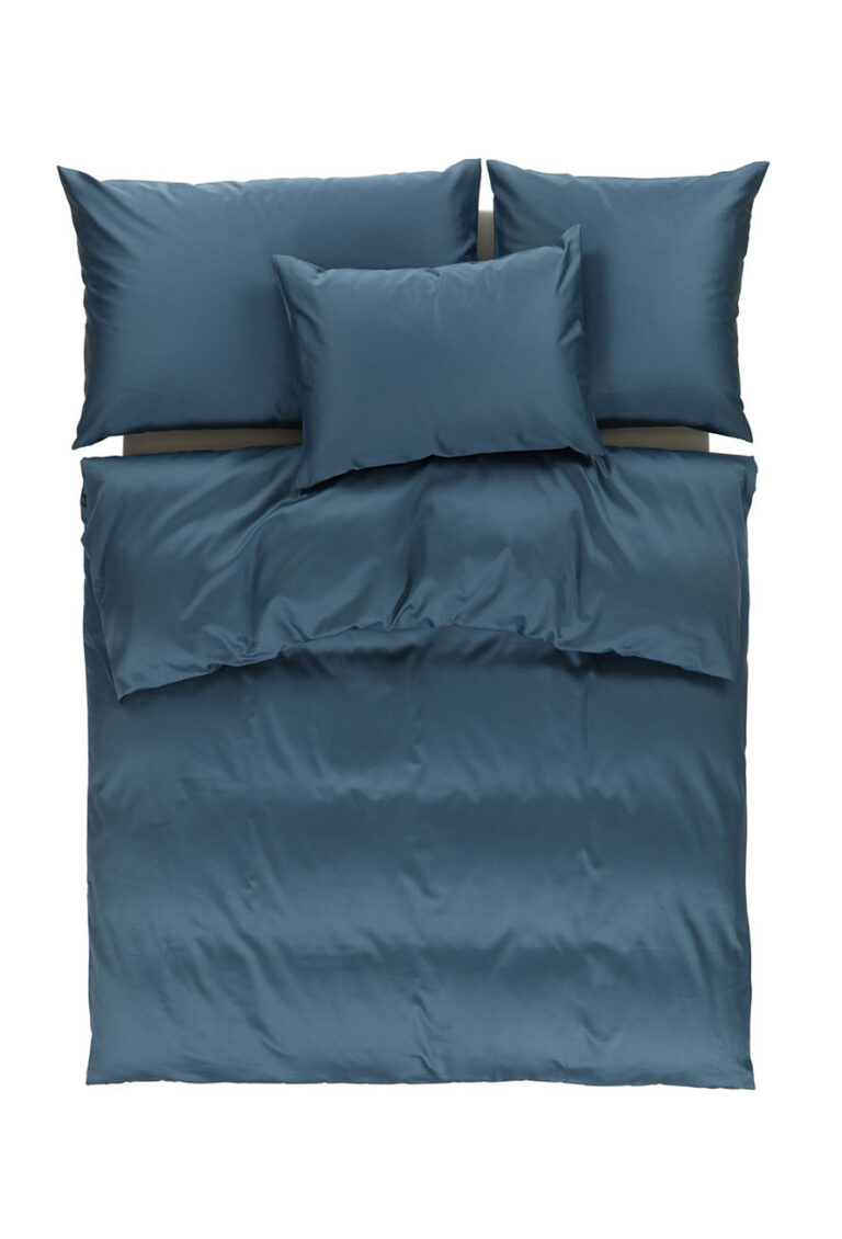 Ein ordentlich gemachtes Bett mit blauer Bettwäsche, einschließlich einer Bettdecke, zwei großen Kissen und einem kleineren Kissen, von oben gesehen vor einem weißen Hintergrund.