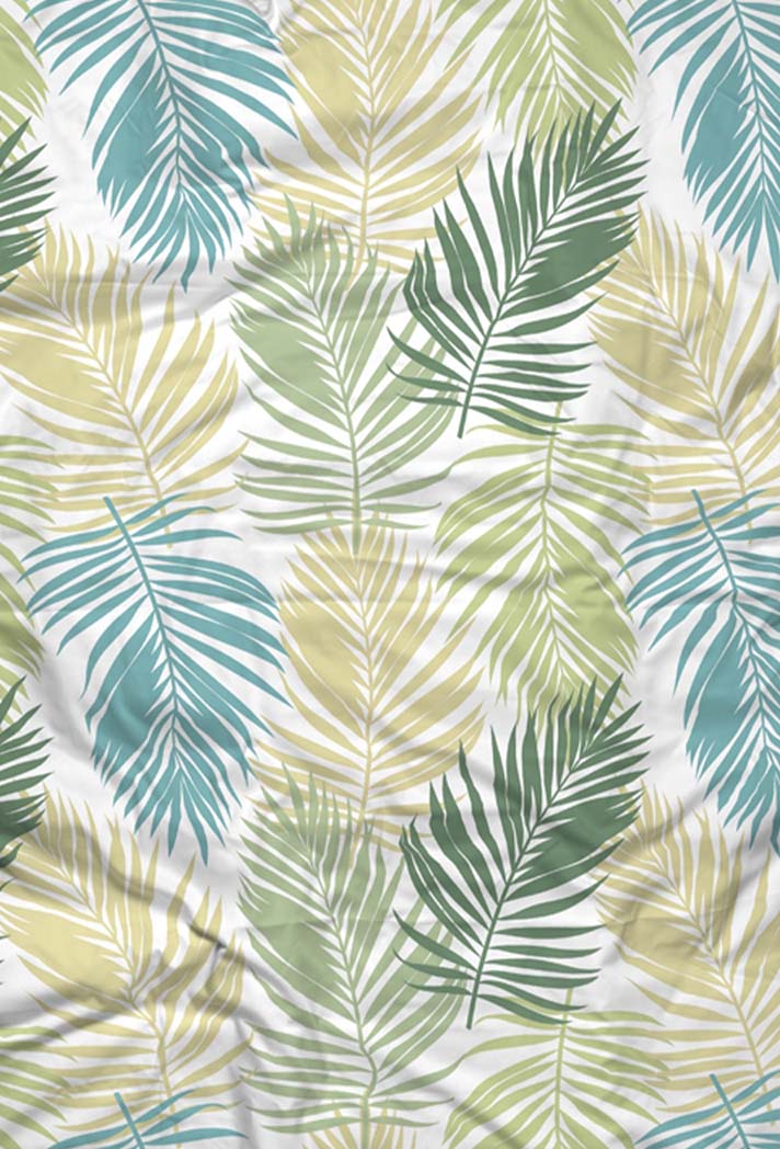 Ein gemusterter Stoff mit sich überlappenden Palmenblättern in Grün-, Blau- und Beigetönen auf weißem Hintergrund. Die Blätter variieren in Größe und Richtung, wodurch ein tropisches und strukturiertes Aussehen entsteht.