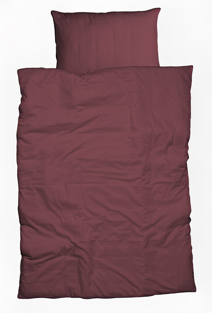 Ein ordentlich gemachtes Bett mit einem passenden Kissen und einer Decke in einer kastanienbraunen oder dunkelburgunderroten Farbe, von oben gesehen vor einem weißen Hintergrund.