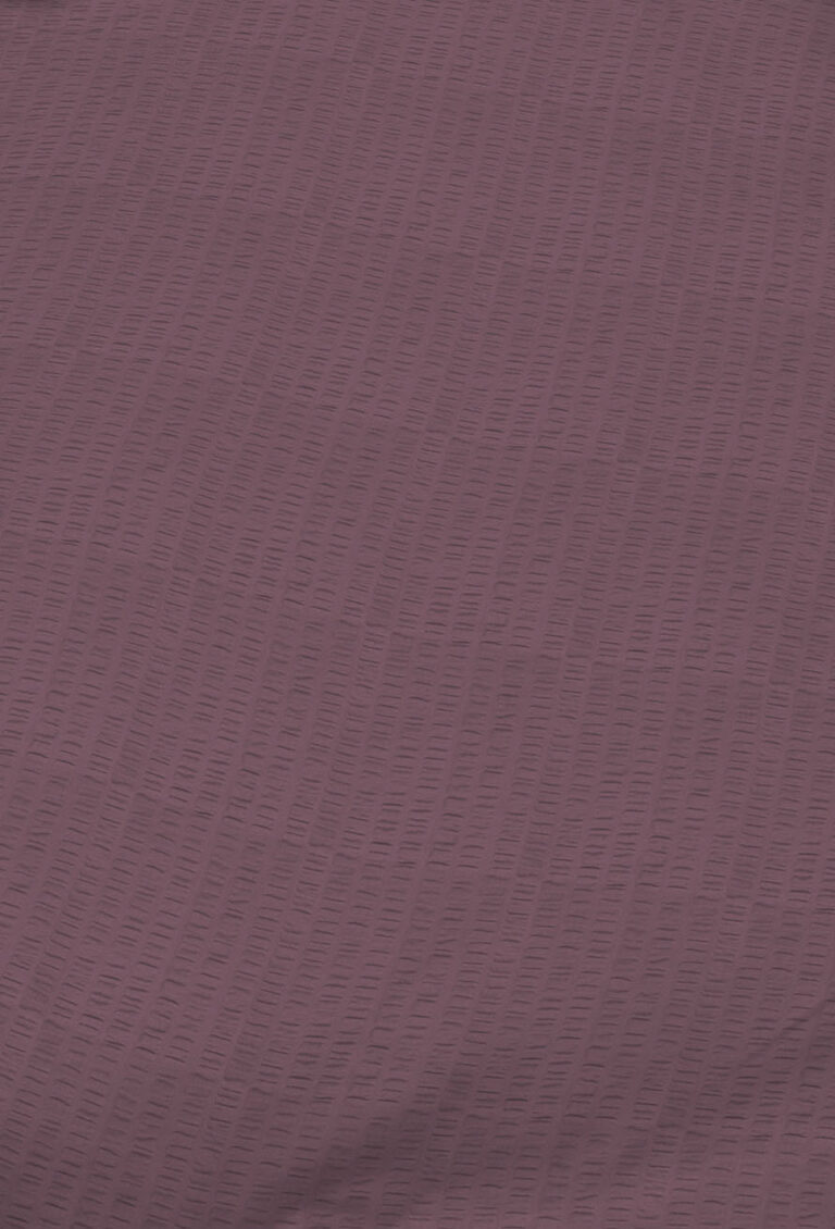 Nahaufnahme eines strukturierten Stoffes in einem gedeckten Violett, der ein subtiles vertikales Muster aus kurzen, erhabenen Linien aufweist, die gleichmäßig über die Oberfläche verteilt sind.